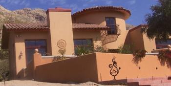 Desert-style home with orange walls and tile ceiling with blue skies